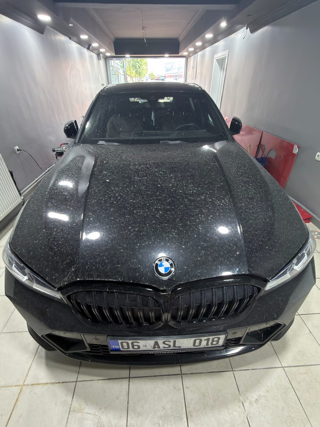 İşlem öncesi: su lekeleri ve tortu içindeki siyah BMW G20 kaputu